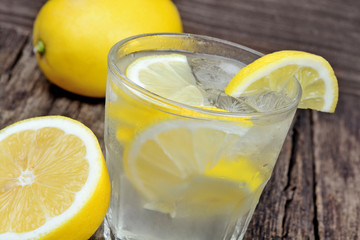 Glass of fresh water with a lemon on table