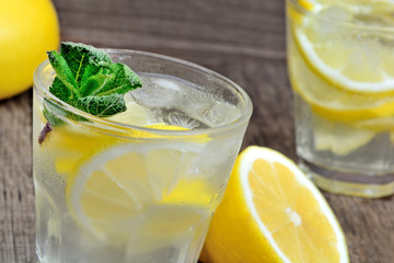 Water with fresh lemon and mint in a glasses on wood table