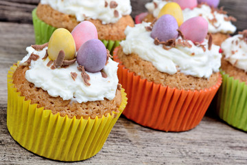  Heap of muffins with chocolate eggs on old table