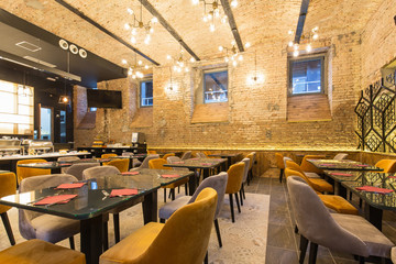 Interior of a modern hotel restaurant with brick wall