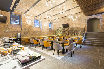 Interior of a modern hotel restaurant with brick wall