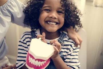 Cheerful young kid holding a dental model © Rawpixel.com