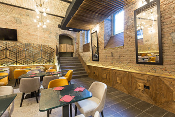 Interior of a modern hotel restaurant with brick wall
