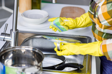 cropped image of woman washing dishes in kitchen