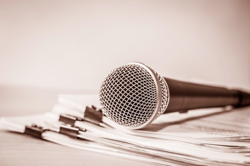 Close up a Microphone with paper document , concept of speaker or teacher preparation to speak in seminar class room