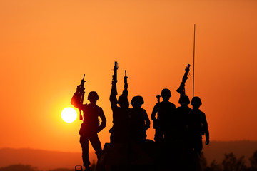 Fototapeta na wymiar Soldiers silhouettes against a sunset. The winner concept.