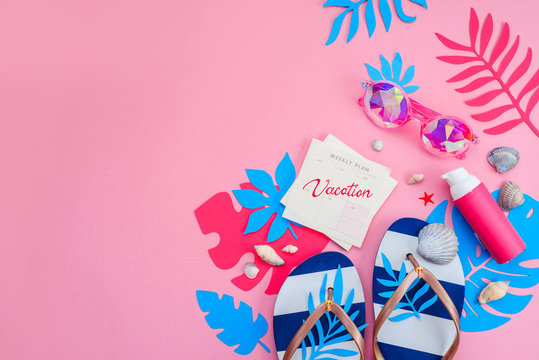 Feminine summer vacation essentials header. Colorful travel flat lay with tropical leaves. Flip flops, sunglasses and sunscreen on a vibrant pink background with copy space.