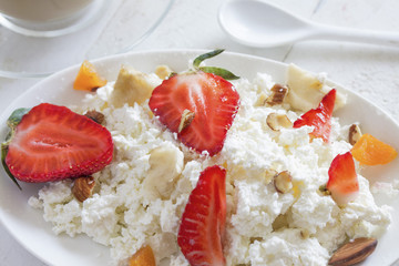 healthy appetizing breakfast of homemade cottage cheese with sliced strawberries close