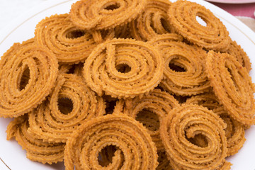 Indian Traditional Snack Chakli, a spiral shaped crisp deep fried snack, It is known as  Chakali, Murukku, Muruku, Murkoo, Chakri in Gujarat, Chakli in Maharashtra and Northern India