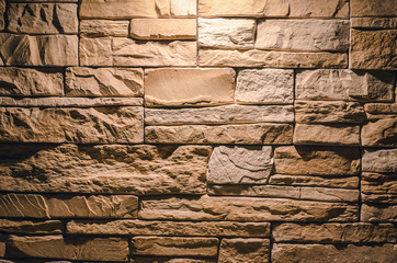 Textured brick wall abstract background with copy space in the light of lamp.