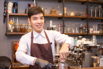 Fototapeta na wymiar Asian male barista making coffee in coffee shop counter. Barista male working at cafe. Man working with small business owner or sme concept.
