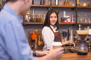 Attractive female barista working at cafe. People working concept.