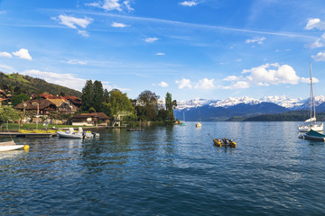 Fototapeta na wymiar Sailing boats in port at lake Thun infornt of Alps mountain