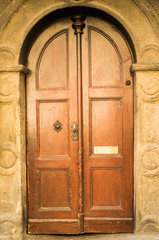 Fototapeta na wymiar Historical Ornate Wooden Door in a Stone Entry with Arc, Prague, The Czech Republic.