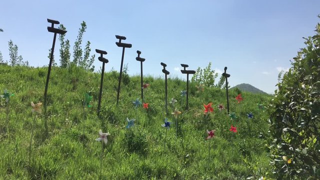 A pinwheel and a Sotdae on the windy day in Daegu, Korea. Sotdae is a pole signifying prayer for a good harvest.