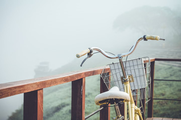 Fototapeta na wymiar Vintage bicycle leaning against a wooden fence River in the foggy park