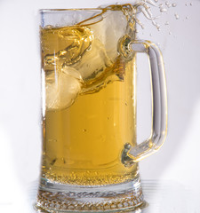 Beer in a glass poured from a bottle thrown from the ice and foam