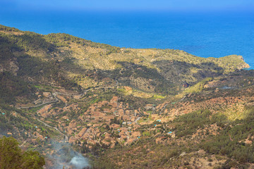 Fototapeta na wymiar Beautiful stone mediterranean village surrounded by mountains in the northwest coast of Majorca. Deia aerial view landscape panorama in Balearic Islands.
