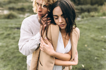 beautiful couple dressed in boho style walking in the sunny forest