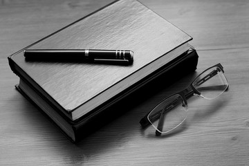 Book, notebook, pen and glasses on the desk. Business, science and education. Working background.
