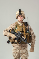 Soldier in camouflage holding rifle