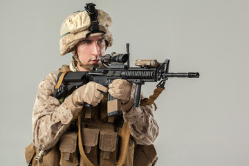 Soldier in camouflage holding rifle