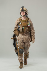 Soldier in camouflage holding rifle