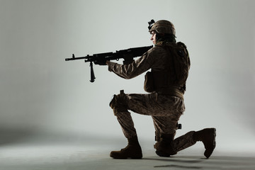 Soldier in camouflage holding rifle