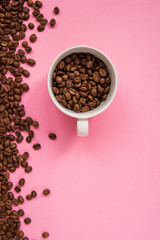 Coffee beans on a pink backround copy space