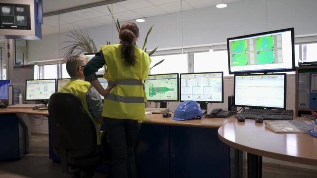 Technicians working in industrial plant control room