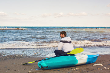 Fototapeta na wymiar Man holding kayak oar against the sea