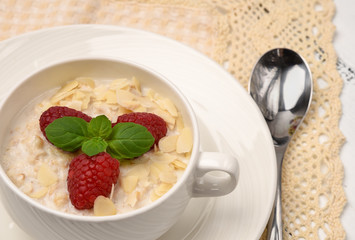 Steel cut oatmeal porridge with raspberry and almond flakes for breakfast
