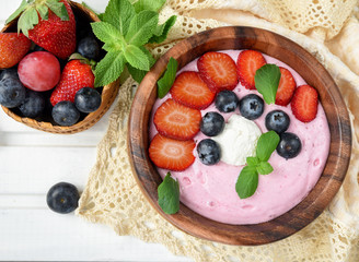Ideas for healthy summer breakfast op dessert. Smoothies in bowls with strawberry, blueberry berry. With oatmeal, fresh berries.