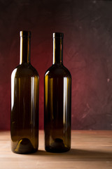 Fototapeta na wymiar Wine bottles on the table against wooden background
