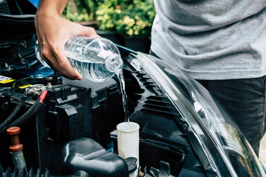 mechanic fill fresh water into windscreen or in water tank wiper on car engine room.