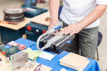 Man working with jig saw. Fretsaw tool stationary fixed on table. Person making wooden figures with...