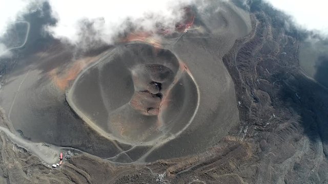 Aerial of Mount Etna volcanic crater one of the flank craters is roughly circular depression in ground caused by volcanic activity and is typically bowl-shaped feature also showing people walking 4k