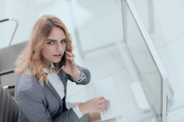 Obraz na płótnie Canvas business woman talking on smartphone in office