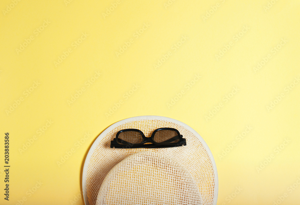 Wall mural concept of leisure and travel, beach, sun hat and sunglasses on a yellow background. summer