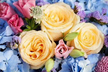 Close up of beautiful soft colour flower bouquet with blue Hydrangea, peach roses, pink lisianthus, ping pong mums and astrantia.