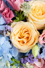 Close up of beautiful soft colour flower bouquet with blue Hydrangea, peach roses, pink lisianthus, ping pong mums and astrantia. Vertical composition
