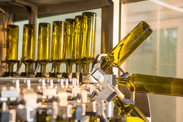 Unlabeled glass bottles in bottling machine at modern winery - 203883768