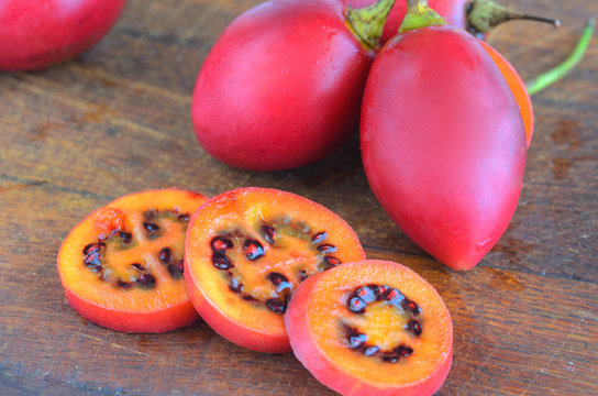 Red tamarillo  or  tree tomato cut into slices on cut board. Exotic fruit Tamarillo background.