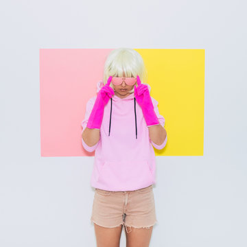 Doll Blonde Girl Model. Fashion accessory sunglasses, gloves,  hoodie and shorts. Club DJ Party Fun. Mood and vibes. Minimal unicorn style. Pink and yellow neon colors. 90s or 80s trend