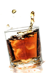 Cola splashing in glass on  white  background