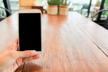Close up of men  hands holding touching mobile phone with blank copy space for your text message in cafe  with light Sunset,Vintage tone.Selective focus