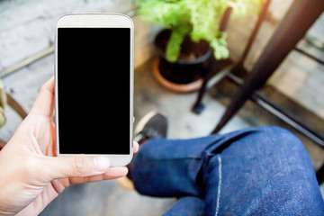 Close up of men  hands holding touching mobile phone with blank copy space for your text message in cafe  with light Sunset,Vintage tone.Selective focus