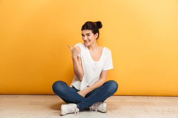 Portrait of a smiling young woman sitting with legs crossed