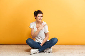 Portrait of a smiling young woman sitting with legs crossed