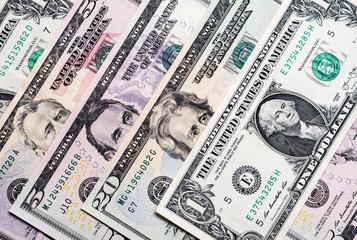 US dollar bills placed evenly on plain surface 